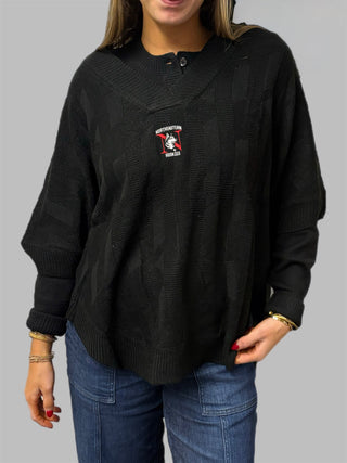 Person wearing a black sweater with a logo on a gray background
