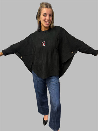 woman wearing black poncho with logo