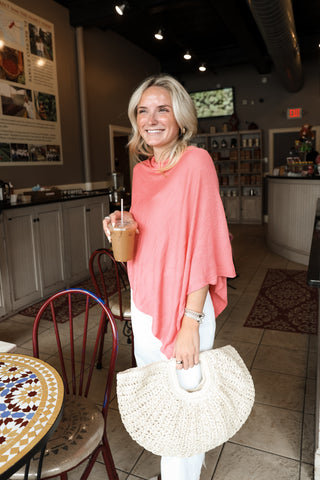 women wearing poncho while holding bag 