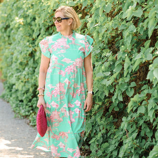 Women wearing long green dress with a pink design
