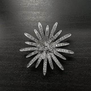 Silver brooch with starburst design and rhinestones