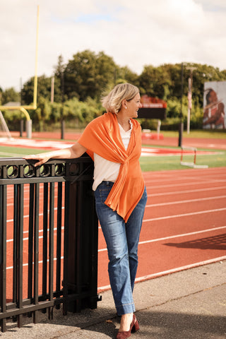 Woman wearing an orange scarf standing on a track field