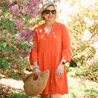 Women wearing orange swing dress with swiss dots