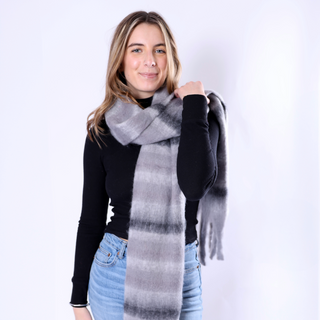 Woman wearing a large gray and black patterned scarf on a white background