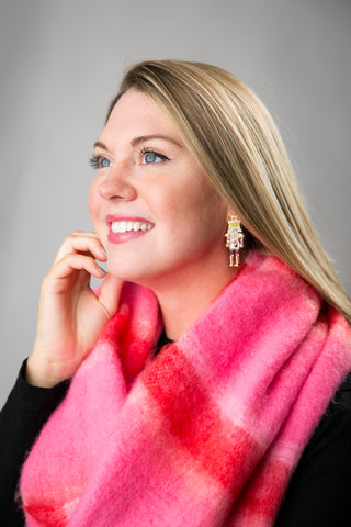 Woman wearing a bright pink scarf against a gray background