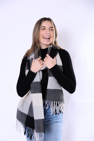 Woman wearing Phoebe Scarf in black and white ribbed plaid with fringe ends.