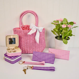 Pink straw bag, gingham jewelry cases, keychains, and sunglasses cases
