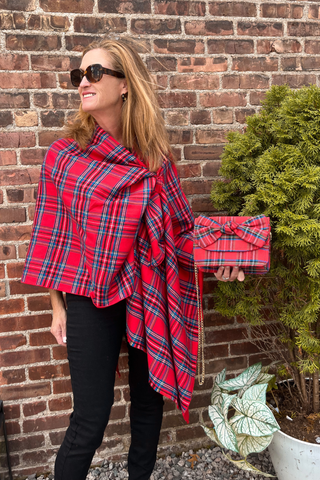 Woman wearing red plaid Keyhole Ruana wrap styled with black pants.
