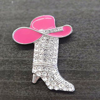 Pink enamel cowgirl hat on silver boot-shaped brooch with clear rhinestones