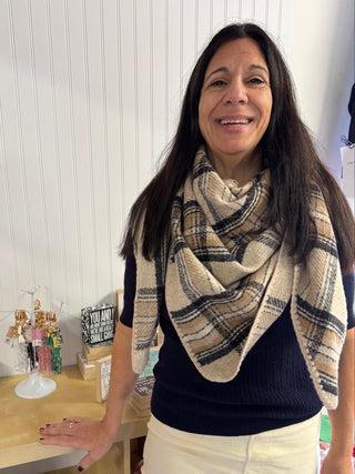 Claire Plaid Wrap/Scarf in camel plaid with whipstitch edging, draped over shoulders.