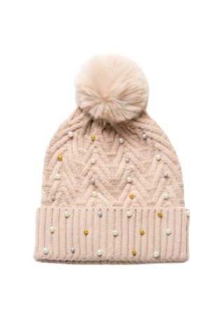 Blush knit hat with pom-pom decorated with pearls and gold balls.
