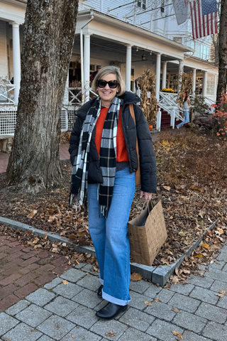 Woman wearing black and white plaid 
sloane scarf 