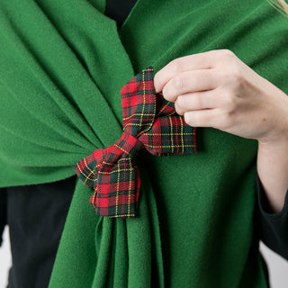 close up of forest green kaden knit keyhole wrap with red and green plaid bow