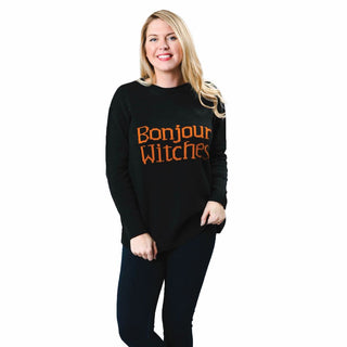 Bonjour Witches in orange knit on black knit sweater with long sleeves