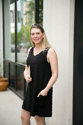 Black sleeveless dress with V-neck, pockets, textured polka-dots